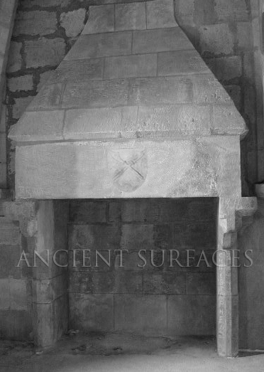 Ancient Norman era fireplace mantle with a threatening coat of arms