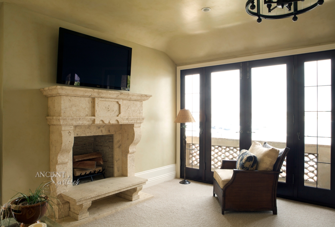 Another Italian inspired simple fireplace hand carved in natural stone installed with a benched raised stone hearth.