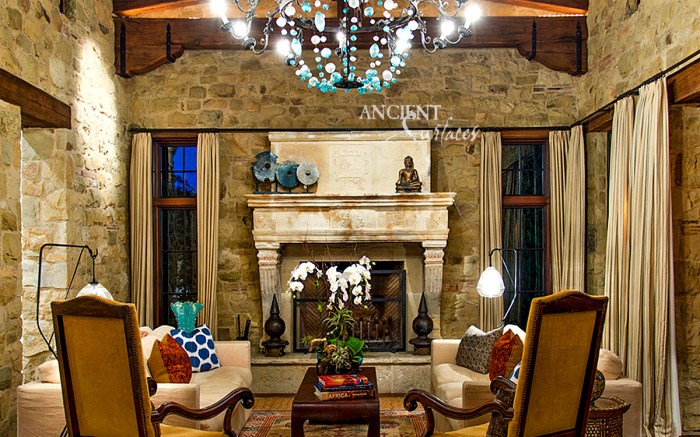 An Antique French limestone fireplace acquired by the current owner of this Mediterranean Countryside style home in Orange Country, California.