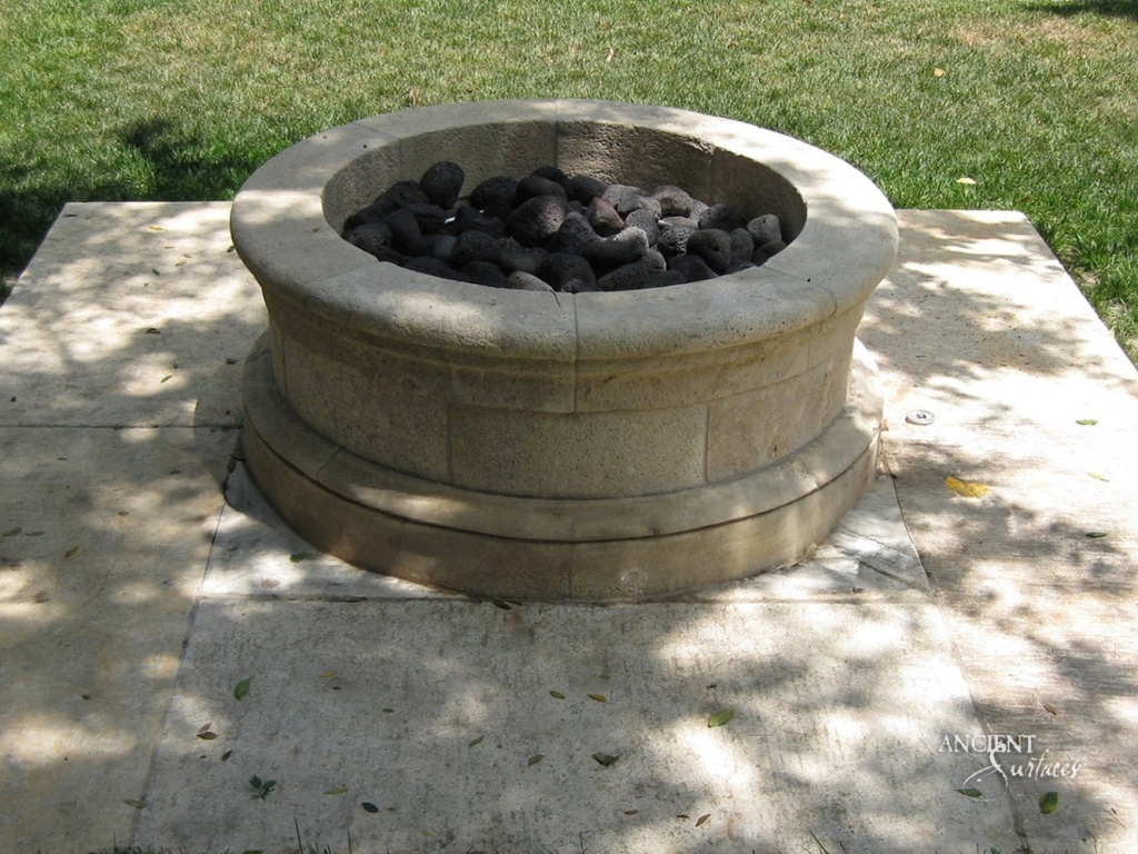 Outdoor living space transformed by a rustic limestone fire pit from Ancient Surfaces, capturing the warmth of ancient surfaces.