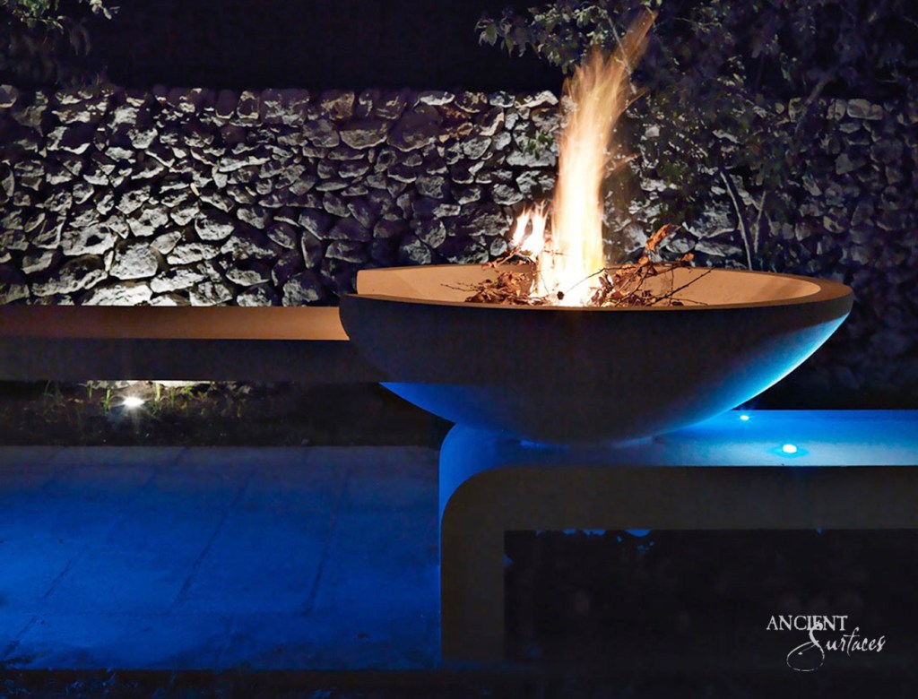 Rustic limestone fire pit by Ancient Surfaces, capturing the essence of outdoor living and the company's commitment to preserving the beauty of ancient surfaces.