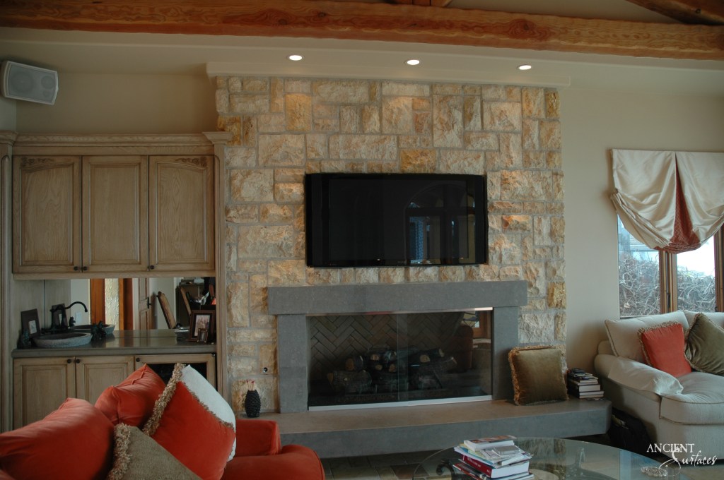 A sophisticated living room fireplace, where ancient stones encase a modern hearth, blending the primal allure of fire with contemporary aesthetics.